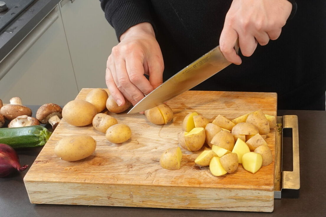 fengemüse, Kartoffeln backen, veganes Rezept, Kartoffeln vorbereiten, Schneidebrett, Messer, grüne Sauce Kräuter, Ofengemüse gesund