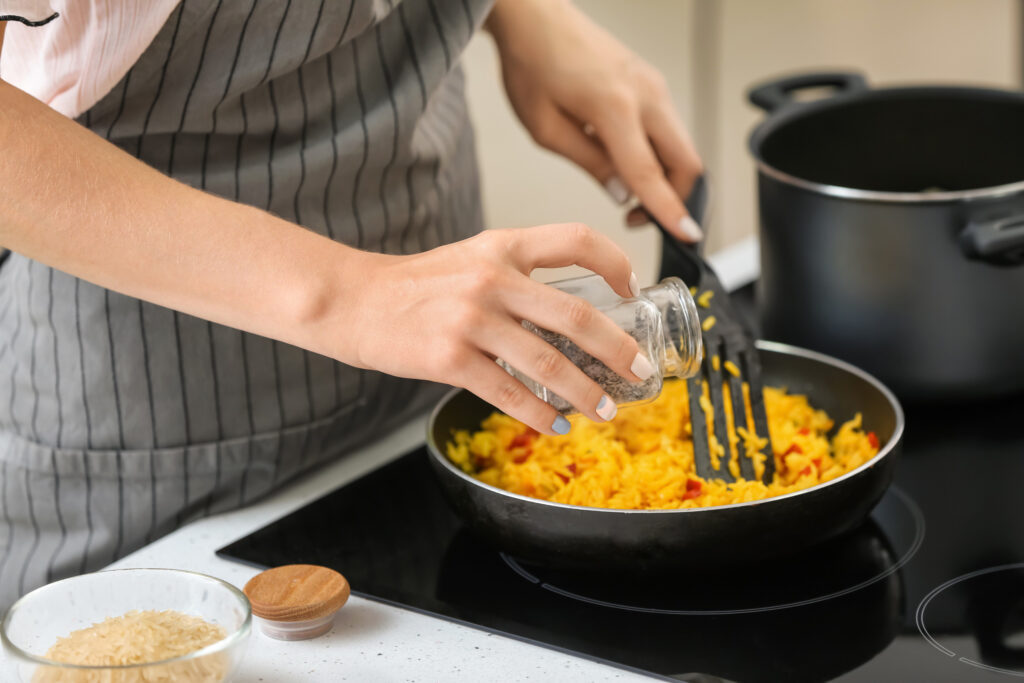 Kochen,Küche,Frau,Pfanne,Reisgericht,Kurkuma,würzen,gesund,lecker